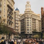 Crowds gather in Valencia's historic city center, surrounded by iconic architecture and vibrant street life.